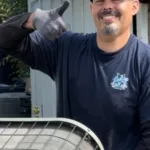 legit air smiling technician giving the thumbs up in front yard of fullerton ca home moving old ac unit across the yard