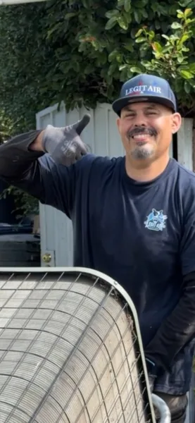 legit air smiling technician giving the thumbs up in front yard of fullerton ca home moving old ac unit across the yard