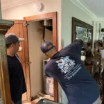 2 certified legit air technicians working on new furnace installed in the hallway of a Whittier ca home